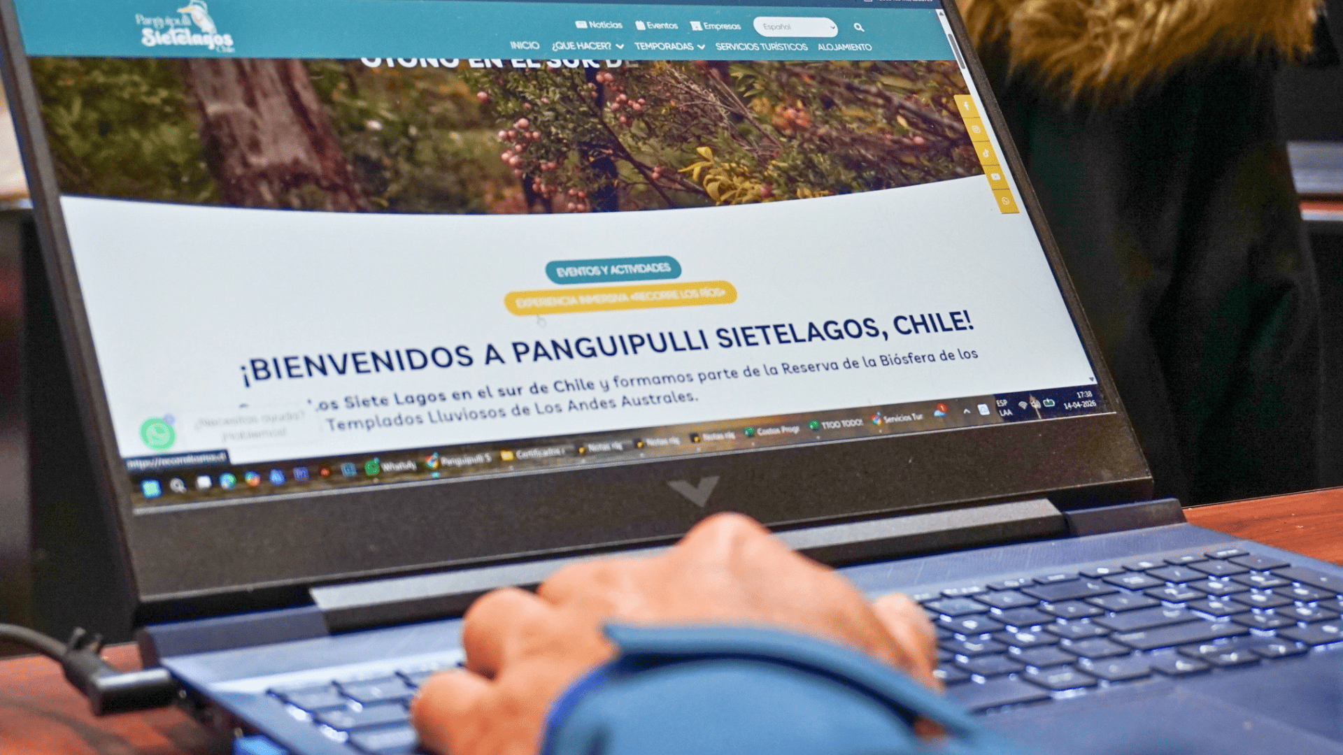 Persona planificando su viaje en el sitio web oficial de Panguipulli Sietelagos desde un computador portátil
